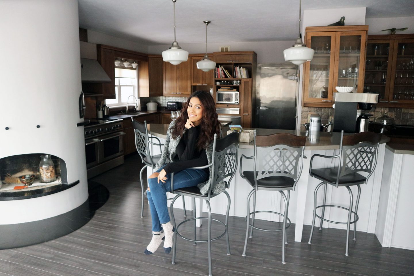 In a bright clean kitchen area, a person smiles while seated.