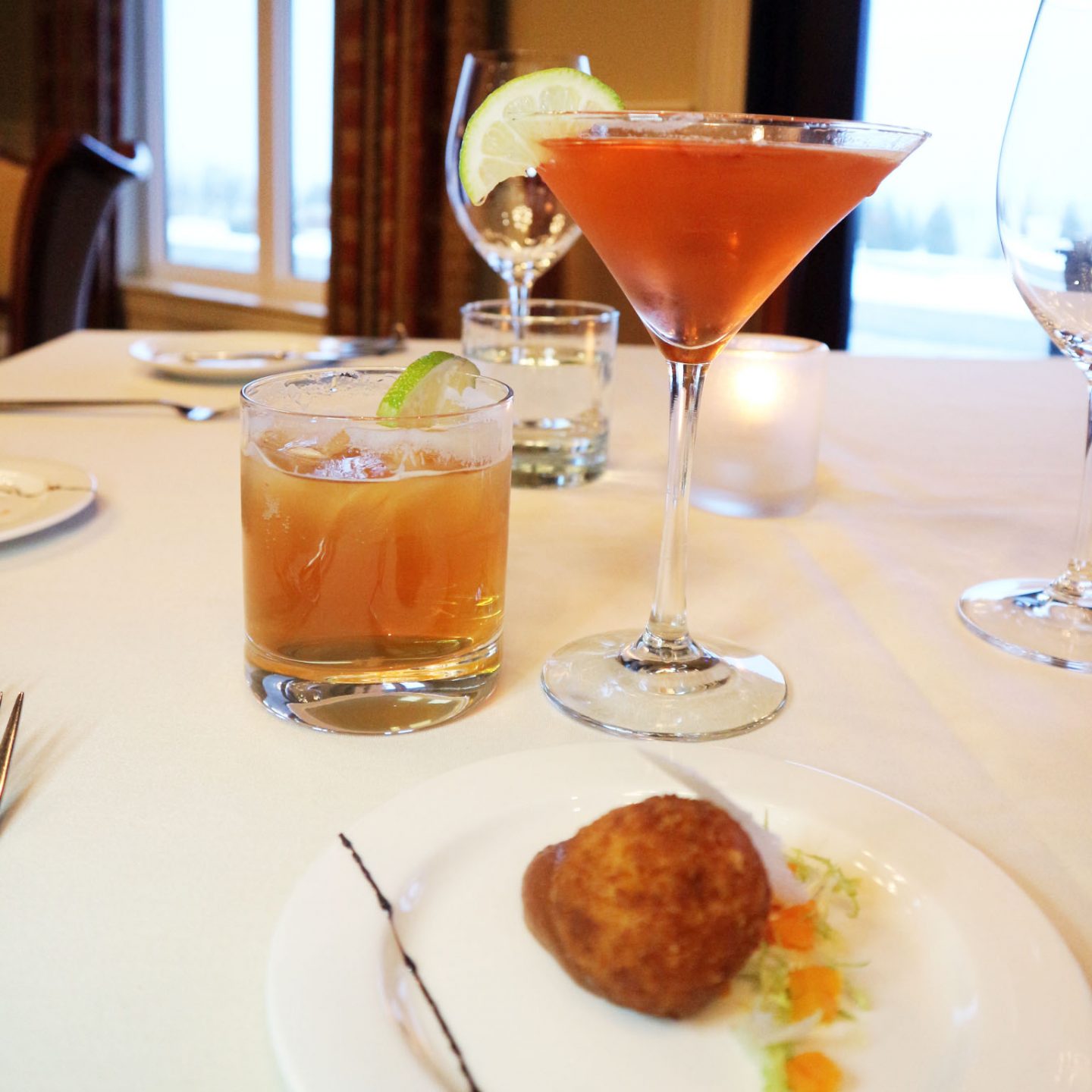 Various drinks on a table with a white tablecloth.