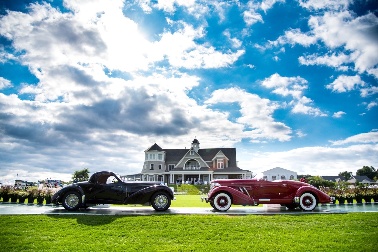 Two classic vehicles parked in front of a large building on a bright summer day.