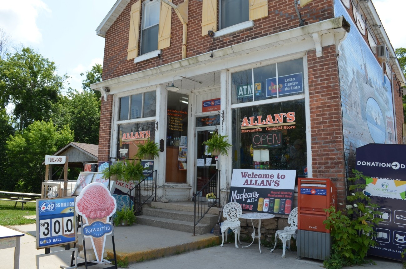 Exterior of a brick store front, sign in window reads ALLAN'S
