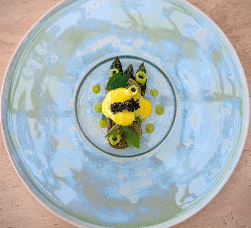 An artful plated meal on a blue plate.