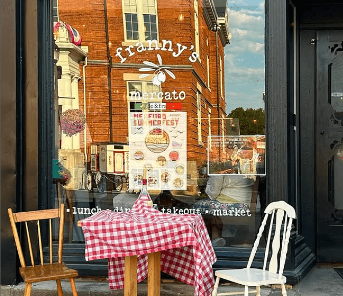 The front of Gio and Fran’s Italian Eatery includes two chairs and a table w