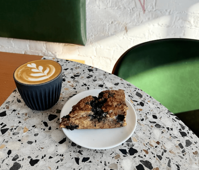 a table with a latte and pastry on it